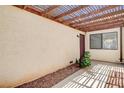 Enclosed patio featuring a wood pergola, desert landscaping, and shade at 8233 Willeta Ave, Las Vegas, NV 89145