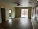 Spacious living room featuring wood floors, a ceiling fan, and access to the backyard at 8745 Dodds Canyon St, Las Vegas, NV 89131
