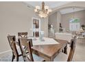 Dining room with dark wood table set under elegant chandelier; open to living space at 9017 Cotton Rose Way, Las Vegas, NV 89134