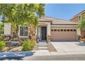 Inviting single-story home featuring stone accents, a two car garage and manicured landscaping at 10121 Iron Wood Peak Ave, Las Vegas, NV 89166