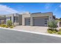 Modern home with a three car garage, well-kept landscaping, and a neutral color scheme on a sunny day at 10927 White Clay Dr, Las Vegas, NV 89135