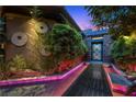 Modern home entrance with unique landscaping, illuminated walkway, and custom front door, creating a welcoming ambiance at 11 Golden Sunray Ln, Las Vegas, NV 89135