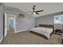 Serene main bedroom with patterned accent wall, ceiling fan, and natural light from the window at 1335 Passiflora Dr, Henderson, NV 89002