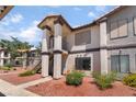 Two-story apartment with stairs, red rock landscaping, light stucco, and dark brown trim at 1575 W Warm Springs Rd # 2822, Henderson, NV 89014