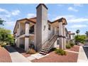 Exterior view of a two-story condominium complex with light stucco, dark trim, and stairs at 1575 W Warm Springs Rd # 2822, Henderson, NV 89014