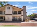 Exterior view of a two-story condo with a balcony, covered parking, and desert landscaping at 1575 W Warm Springs Rd # 2822, Henderson, NV 89014