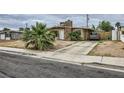 Ranch home with a stone chimney, desert landscaping and extended driveway at 1607 Vegas Valley Dr, Las Vegas, NV 89169