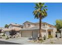 Attractive two-story home with a well-manicured lawn, mature palm tree, and a three car garage at 1906 Desert Sage Ave, North Las Vegas, NV 89031