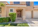 Inviting front entrance with a well-kept lawn and mature landscaping accentuating the covered entryway to the home at 2117 Desert Peak Rd, Las Vegas, NV 89134