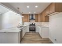 Renovated kitchen showcasing new cabinets, stone countertops, stainless steel appliances, and wood flooring at 2117 Desert Peak Rd, Las Vegas, NV 89134