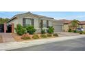 Single-story home with a two-car garage, desert landscaping, and a paved driveway at 2433 Amatrice St, Henderson, NV 89044