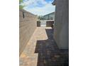 Paver walkway along a tall block wall leading to a gated outdoor area at 289 Aravalli Crest St, Henderson, NV 89015