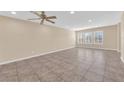 Spacious living room with tile flooring, neutral walls, and bright natural light from shuttered windows at 3064 Bicentennial Pkwy, Henderson, NV 89044