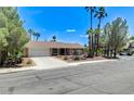 Charming single story home featuring a spacious driveway, xeriscaped front yard, and palm trees at 3360 Paso Andres St, Las Vegas, NV 89146