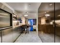 Contemporary stainless steel kitchen with bar seating adjacent to living area, with marble flooring at 4381 Flamingo Rd # 2612, Las Vegas, NV 89103