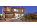 Inviting home featuring a well-lit exterior, attached garage, and attractive desert landscaping at 5480 Oatfield St, North Las Vegas, NV 89081