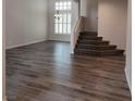 Bright and spacious living room with new flooring, large windows, and a staircase at 5509 Big Sky Ln, Las Vegas, NV 89149