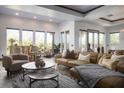 Bright and airy living room boasts stylish furnishings, large windows, and seamless outdoor access at 64 Tapadero Ln, Las Vegas, NV 89135