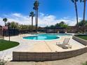 Community pool with lounge chairs surrounded by landscaping and palm trees at 6445 Ironbark Ln, Las Vegas, NV 89107