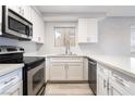 Modern kitchen with white cabinets, stainless steel appliances, and light countertops at 6871 Tamarus St # 204, Las Vegas, NV 89119