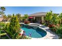 Relaxing pool surrounded by beautiful flowers, shrubs, and trees at 8221 Bay Dunes St, Las Vegas, NV 89131