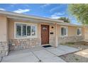 Inviting front entrance with a stylish wood door, stone accents, and a cozy covered porch area at 839 Benita Pl, Boulder City, NV 89005