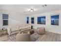 Cozy living room with plush seating, large windows, and neutral decor at 12367 Aster Hills Ave, Las Vegas, NV 89138