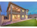 Spacious backyard featuring a covered patio, synthetic grass, and a private outdoor living space at 12404 Aster Hills Ave, Las Vegas, NV 89138