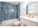 Contemporary bathroom showcasing blue tiling, white vanity with quartz countertop, and brass hardware at 1731 Sherwin Ln, Las Vegas, NV 89156
