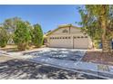 Attractive single-story house with a three-car garage, desert landscaping, and a paved driveway at 1905 Dakota Hills Ave, Las Vegas, NV 89123