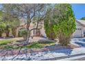 Front yard of a single-story home with lush landscaping and a cozy outdoor seating area at 1905 Dakota Hills Ave, Las Vegas, NV 89123