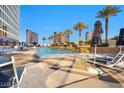 A luxurious pool area surrounded by lounge chairs, palm trees and city views creates a resort-like atmosphere at 2000 N Fashion Show Dr # 5326, Las Vegas, NV 89109