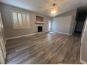 Open-concept living room with a fireplace, neutral paint, and luxury vinyl plank flooring at 2694 Hillgrass Rd, Las Vegas, NV 89123