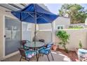 Cozy outdoor patio space with a blue umbrella, dining table, and seating area at 2749 Lodestone Dr, Las Vegas, NV 89117