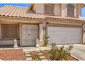 Close up of front exterior of house with two-car garage and decorative lion statues by front door at 3440 Meridale Dr, Las Vegas, NV 89117