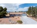 Inviting single-story home featuring a tile roof, two-car garage, and low-maintenance desert landscaping at 480 China St, Pahrump, NV 89048