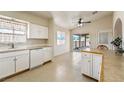 Bright kitchen features white cabinets, tile flooring, and sliding door to outdoor space at 480 China St, Pahrump, NV 89048