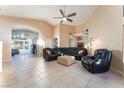 Bright living room with tile flooring, a vaulted ceiling, ceiling fan, and comfortable black leather seating at 5350 Sharon Marie Ct, Las Vegas, NV 89118