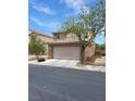Two-story home featuring a tile roof, two car garage, and low maintenance desert landscaping at 5477 Ovando Way, Las Vegas, NV 89122