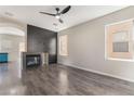 Bright living room features a fireplace with black accent wall and modern ceiling fan at 6260 Castle Kennedy St, Henderson, NV 89011