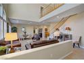 Bright, open-concept living room featuring high ceilings, large windows, and a cozy seating area at 6440 Bristlebird St, North Las Vegas, NV 89084