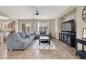 Comfortable living room featuring tile floors, gray sofas, and a view to the backyard at 6869 Desert Thrasher Dr, North Las Vegas, NV 89084