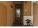 Close up of front door featuring sidelight and decorative pot on small table at 7630 Canyon Diablo Rd, Las Vegas, NV 89179