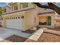 Inviting home exterior featuring a two-car garage, cozy porch, and manicured landscaping at 7637 Good Fortune Ct, Las Vegas, NV 89139