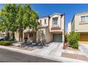 Two-story home featuring a covered porch, attached garage, and mature landscaping at 7645 Interlace St, Las Vegas, NV 89149