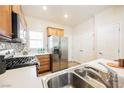 Bright kitchen showcases stainless steel refrigerator, gas range, and tiled backsplash at 7957 Fantail Dr, North Las Vegas, NV 89084