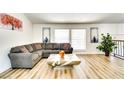 Bright living room with wood floors, a large sectional sofa, modern art, and large windows for natural light at 864 E Eldorado Ln, Las Vegas, NV 89123