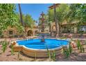 Outdoor space with a tiered fountain surrounded by vibrant flowers and lush greenery at 9024 Starmount Dr, Las Vegas, NV 89134