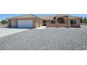 Exterior elevation of a stucco home featuring a wide driveway and a three-car garage at 1361 Moose St, Pahrump, NV 89048