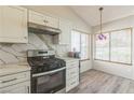 Bright kitchen featuring white cabinets, stainless steel appliances, and laminate flooring at 169 Alterra Dr, Henderson, NV 89074